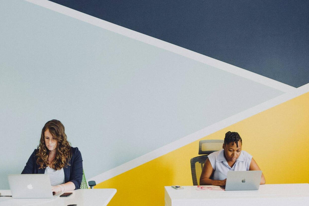 Deux professionnels travaillant sur ordinateur dans un bureau moderne – placement de ressources TI qualifiées