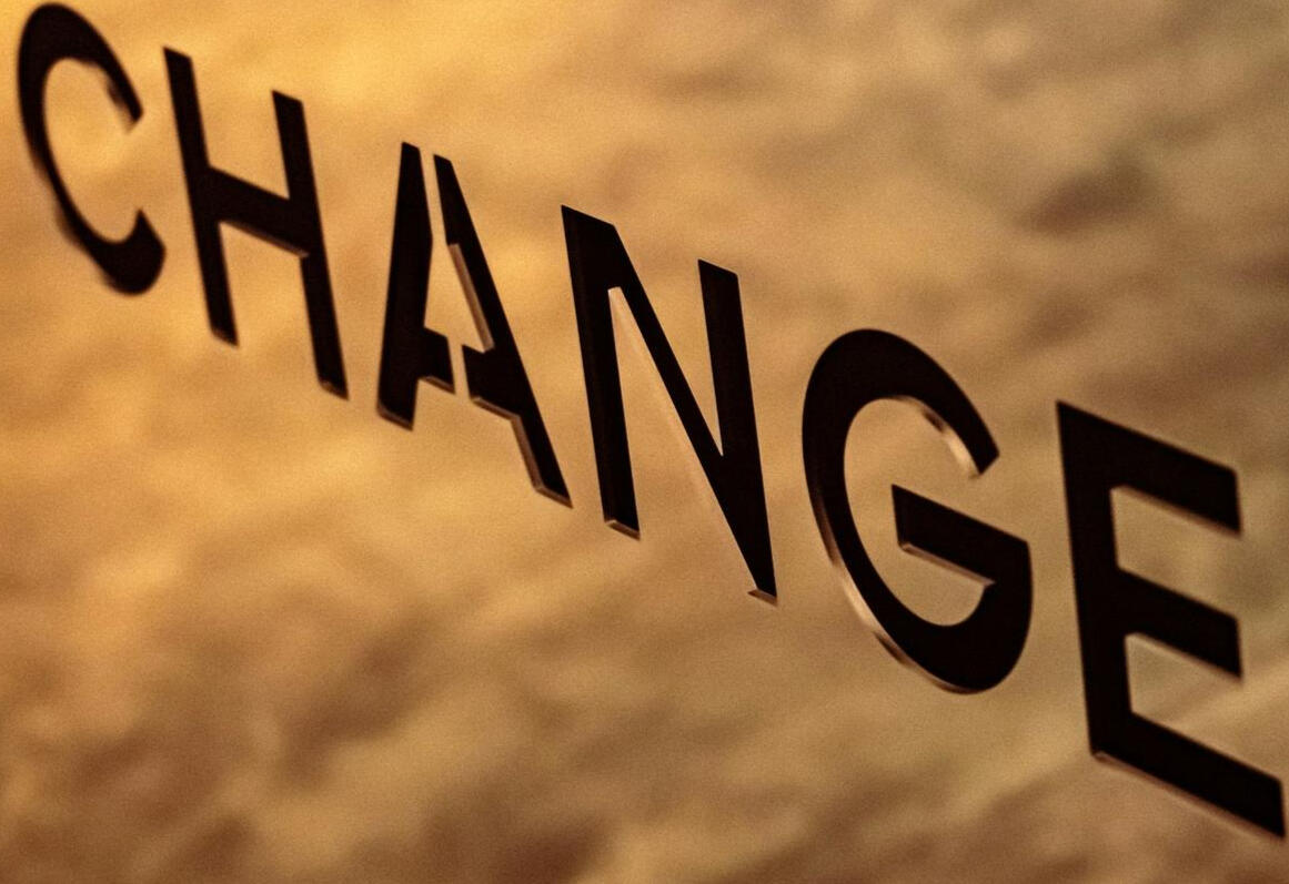 FAQ – Vos questions sur la consultation, la formation et le coaching TI Mot CHANGE reflété sur une surface, symbolisant la transformation et l’adaptation en gestion de projets TI.